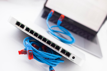 Smart office concept.  Silver switch and new laptop on the white background. Network configuration...