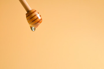 Dipper honey on orange background. Copy space.