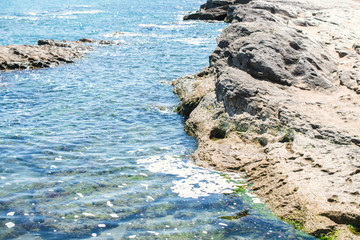 Wonderful sea blue waves crashing on a gray rock. High wave splashing on the cliff.