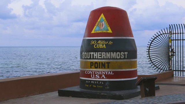 Beautiful closeup view of Southernmost Point Buoy on blue water of Atlantic OCean and blue sky background. Tourist attraction. Key West, Florida. USA. 