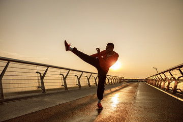 Focused athletic man exercising on a bridge