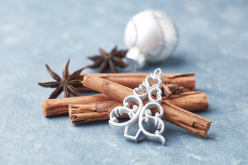 Christmas ornaments, cinnamon sticks and star anise. Christmas spices on rustic wooden background. Close up. 