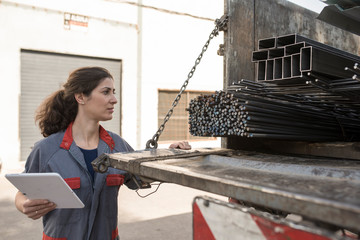 Woman looking construction iron on truck