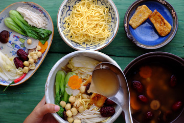 People prepare vegetarian homemade noodle soup bowl from vegan ingredient
