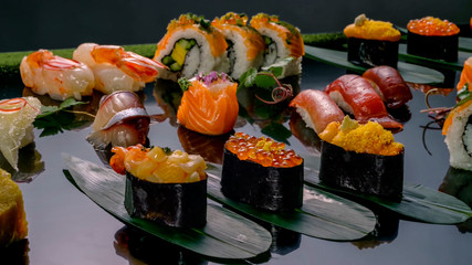 sushi and rolls are laid out on the table. salmon and red caviar. crab meat. rice and soy sauce. Japanese rolls