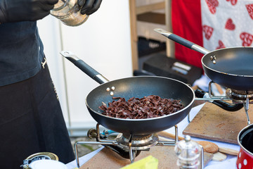 Chef preparing delicious organic pasta dish outdoor.
