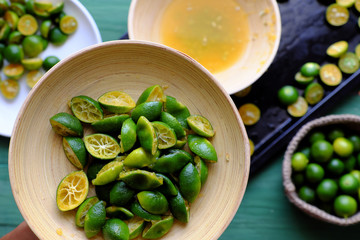 Top view people hand hold kumquat peel in green