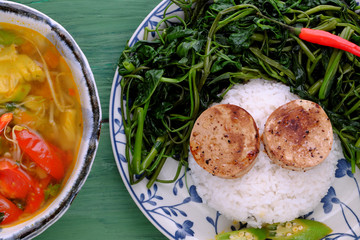 vegetarian meal, rice dish with boiled water morning glory, vegan sausage, sour soup bowl