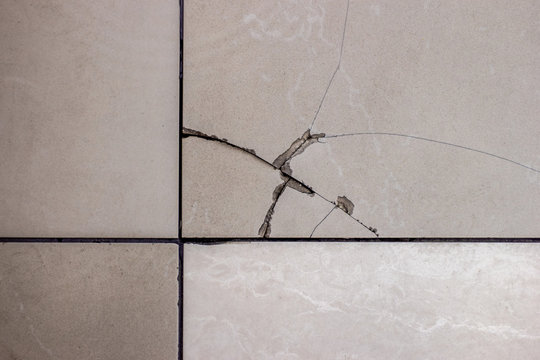 Cracked Tile. Broken Tile On The Floor.