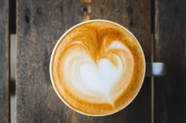 close up modern hot black coffee the cappuccino on wood background with coffee bubble foam pattern and texture in white cup looking and feel so delicious on glasses table in coffee shop.