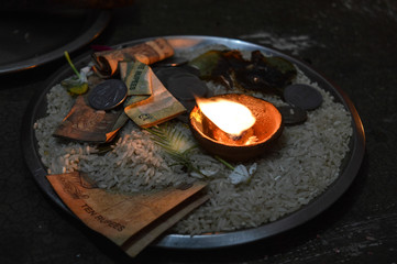 A jar is which is loaded with rose and candle on indian festival diwali deepawali with fire isolated on table