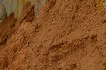 A small sand mountain on the side of road in polluted city, micro shot.