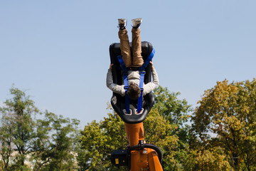 boy upside down on a carousel in an amusement park