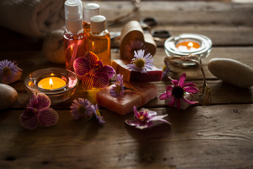Natural spa products and decor for bath. Handmade herbal soap, organic oil, orchid flowers,sea stones,candles and gift boxes on wooden desk, layout photo.