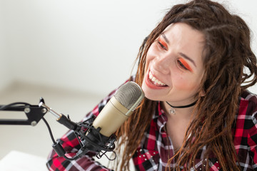 Blogger, radio host and people concept - Expressive modern DJ girl with dreadlocks working at the radio