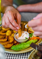 man hand with plate with snacks on table background on bar or pub