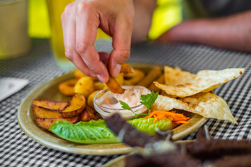 man hand with plate with snacks on table background on bar or pub