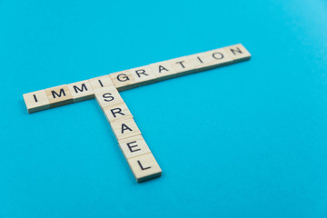 Immigration minimalistic concept. Isolated wooden letter blocks with word cloud Immigration to Israel