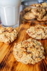 oatmeal cookies with apples and milk on a wooden board