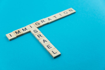 Immigration minimalistic concept. Isolated wooden letter blocks with word cloud Immigration to Israel