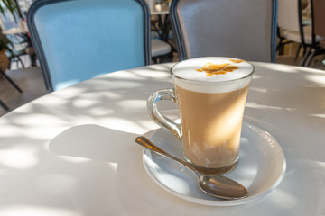 coffee latte macchiato in glass with frothy milk on table in cafe, concept of morning coffee
