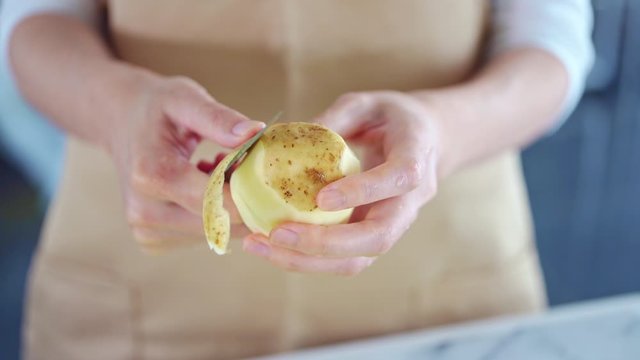 じゃがいもの皮をむく女性