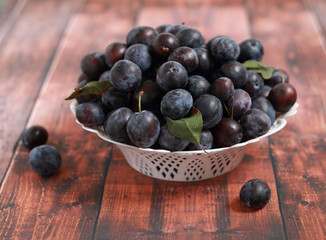 blue plums from his garden on a wooden table