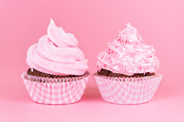 close up of birthday cupcakes decorated whipped cream icing on pink background, concept for holiday