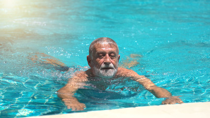 Senior man swimming in  swimming pool