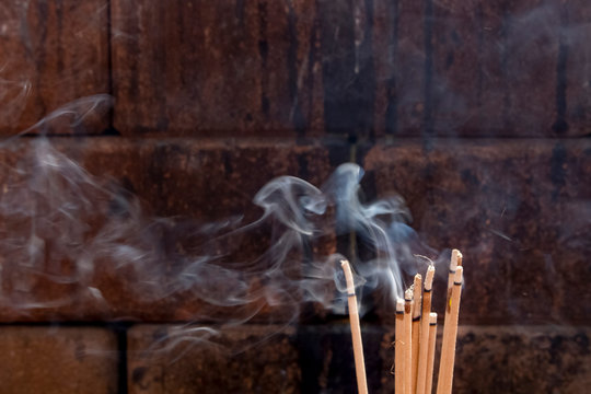 Incense, burning sticks with massive smoke.