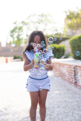 beautiful girl  Shooting Bubbles from Bubble Gun in the park