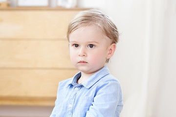 The concept of childhood and child development. The child is at home. A close-up portrait of the face of a pensive blond little boy. A child in kindergarten. Offended boy, upset child. Sad boy