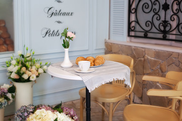 Tasty breakfast cup of coffee with croissants near bakery in morning. Continental traditional breakfast. Breakfast at street cafe. Good morning. Morning coffee on the terrace. Breakfast outside. decor