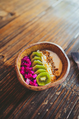 Yoghurt and fruit with grains in a wooden cup