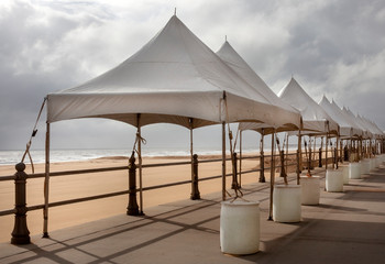 Empty festival arts and crafts event tents erected on Atlantic Ocean beach boardwalk.