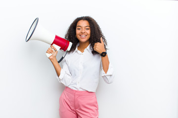 young pretty black woman with a megaphone against white wall