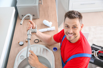 Obraz premium Plumber installing sink in kitchen