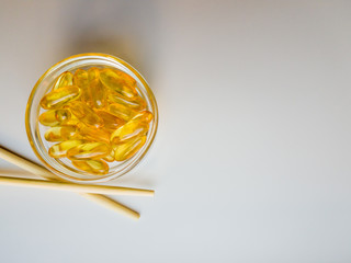 Fish oil capsules in a transparent plate. A lot of vitamin omega-3 against the background of nature and the park. Close up, high resolution product. Metabolism in the body. The body of calcium. 