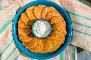 Homemade potato pancakes, latkes, draniki, hash browns or fritters served with sour cream. Traditional Hanukkah treats. Top view. Closeup