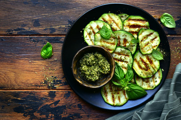 Grilled zucchini slices with basil pesto.Top view with copy space.
