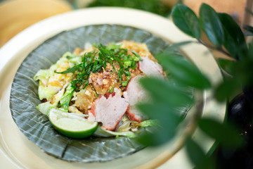 Pad Thai Noodle with lemon, pork sliced and vegetables. Thai dry noodle with topping in leaf dishes.