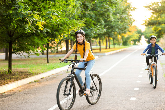 Cute children riding bicycles outdoors