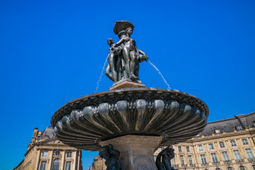 Fototapeta na wymiar Place de la Bourse in Bordeaux France, view of Les Trois Graces, the famous fountain in the center of the square on a sunny day