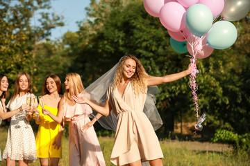 Beautiful young women with champagne at hen party outdoors
