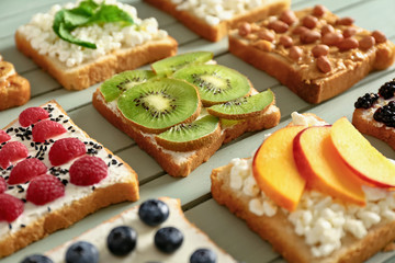 Different tasty sandwiches on wooden background