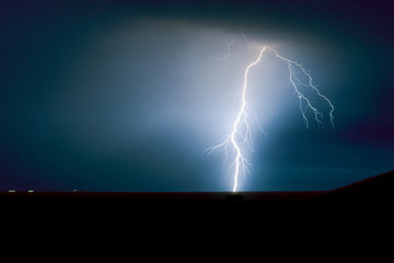 Powerful branched of forked lightning bolt strikes down to earth