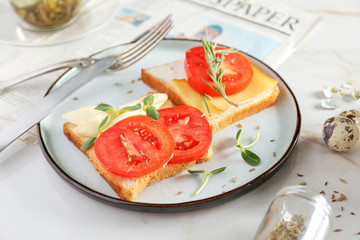 Plate with tasty sandwiches on table