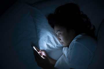Asian woman play smartphone in the bed at night,Thailand people