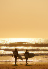 Surfers stroll to the indian ocean