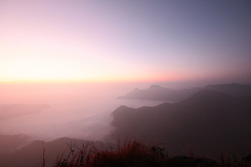 Beautiful golden natural sunlight and twiligh of sunrise shining to in the mist on valley of mountain in Thailand